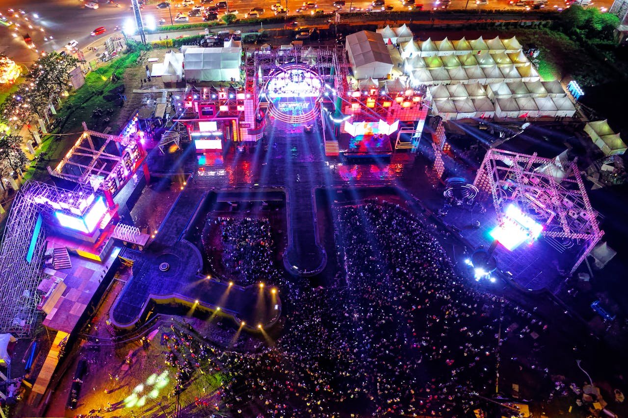 digital-01 Aerial view of a vibrant music festival in Serpong, Indonesia with crowds and stage lights.