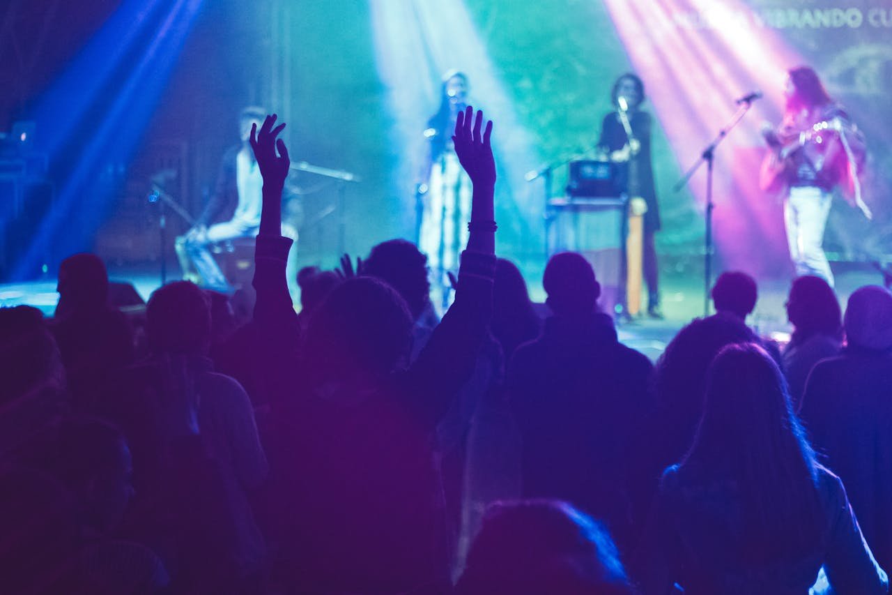 mobile-02 A lively concert scene with musicians performing on stage and an enthusiastic audience.