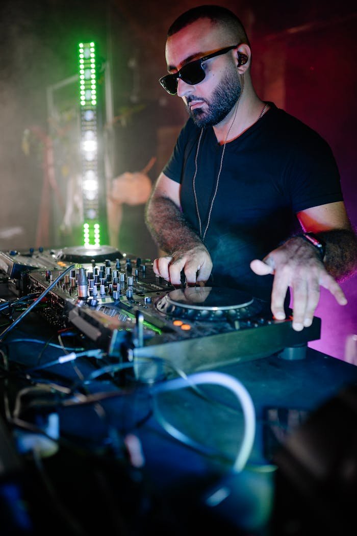 brand-01 DJ spinning tracks at a lively nightclub event with vibrant lighting and energetic atmosphere.